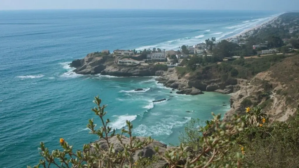 Coastal area with sandy beaches, cliffs, homes, and greenery, California real estate.