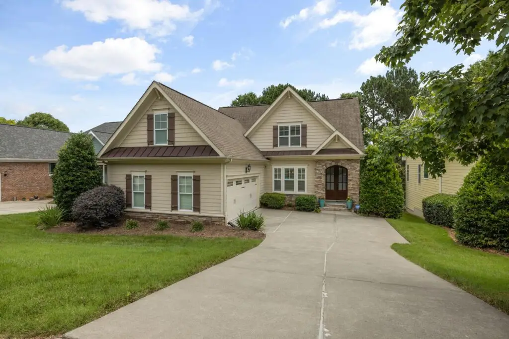 Suburban two-story house with driveway and landscaped yard, California real estate.